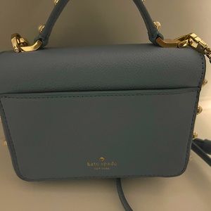Kate Spade baby blue in color and small purse in size with pearls and gold.